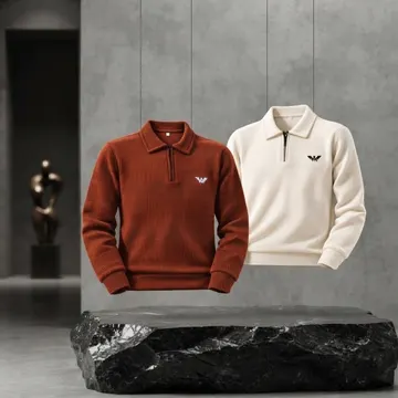 Two floating knit sweaters in rust and cream above a black marble slab in a modern concrete room