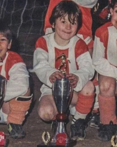 Young soccer player holding silver trophy with golden figure on top