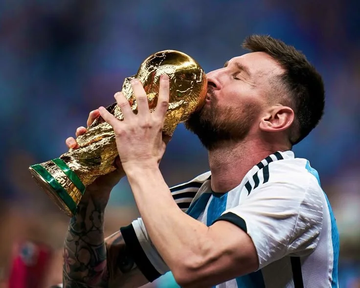 Lionel Messi kissing the World Cup trophy in his Argentina jersey