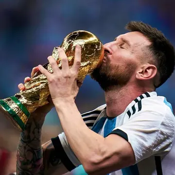 Lionel Messi kissing the World Cup trophy in his Argentina jersey