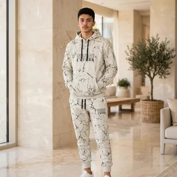 Young man in marble-patterned hoodie and joggers standing in a luxury lobby