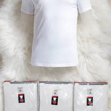 White t-shirt on mannequin with packaged shirts and store plaque on fluffy rug