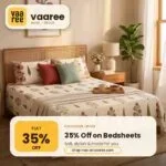 Wooden bed with patterned bedsheet and pillows in a cozy bedroom with plant and lamp