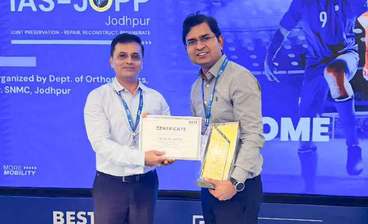 Two men holding an award certificate and trophy at a medical conference event