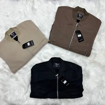 Three folded DLJ bomber jackets in beige brown and black on white faux fur