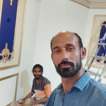 Two men in a room with ornate gold-trimmed blue wall panels and a ladder