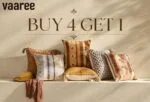 Row of patterned pillows in earth tones on a white shelf with a promotional sign above