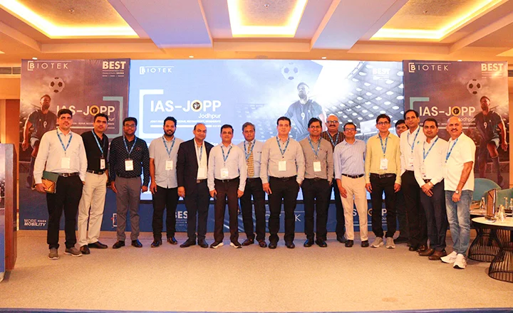 Group of men in business attire posing for a photo at a conference event