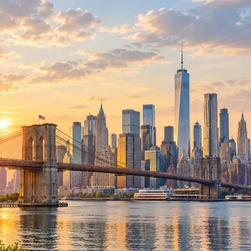 Brooklyn Bridge at sunset with New York City skyline and One World Trade Center in background