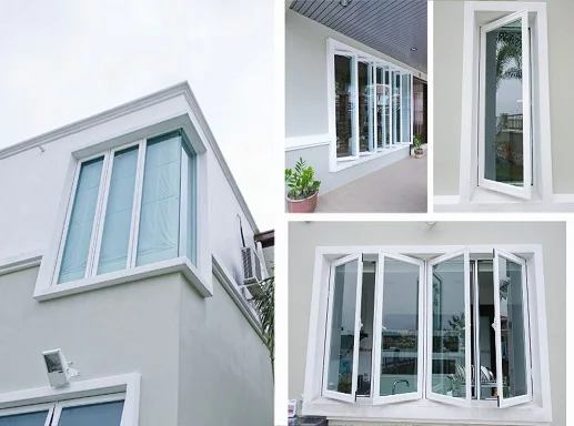 White modern windows on a gray house with glass reflecting sky and greenery