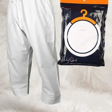 White pants and packaged pants displayed on fluffy white fur with gold store plaque