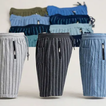 Three striped men's shorts with zipper pockets and drawstrings displayed in front of folded underwear